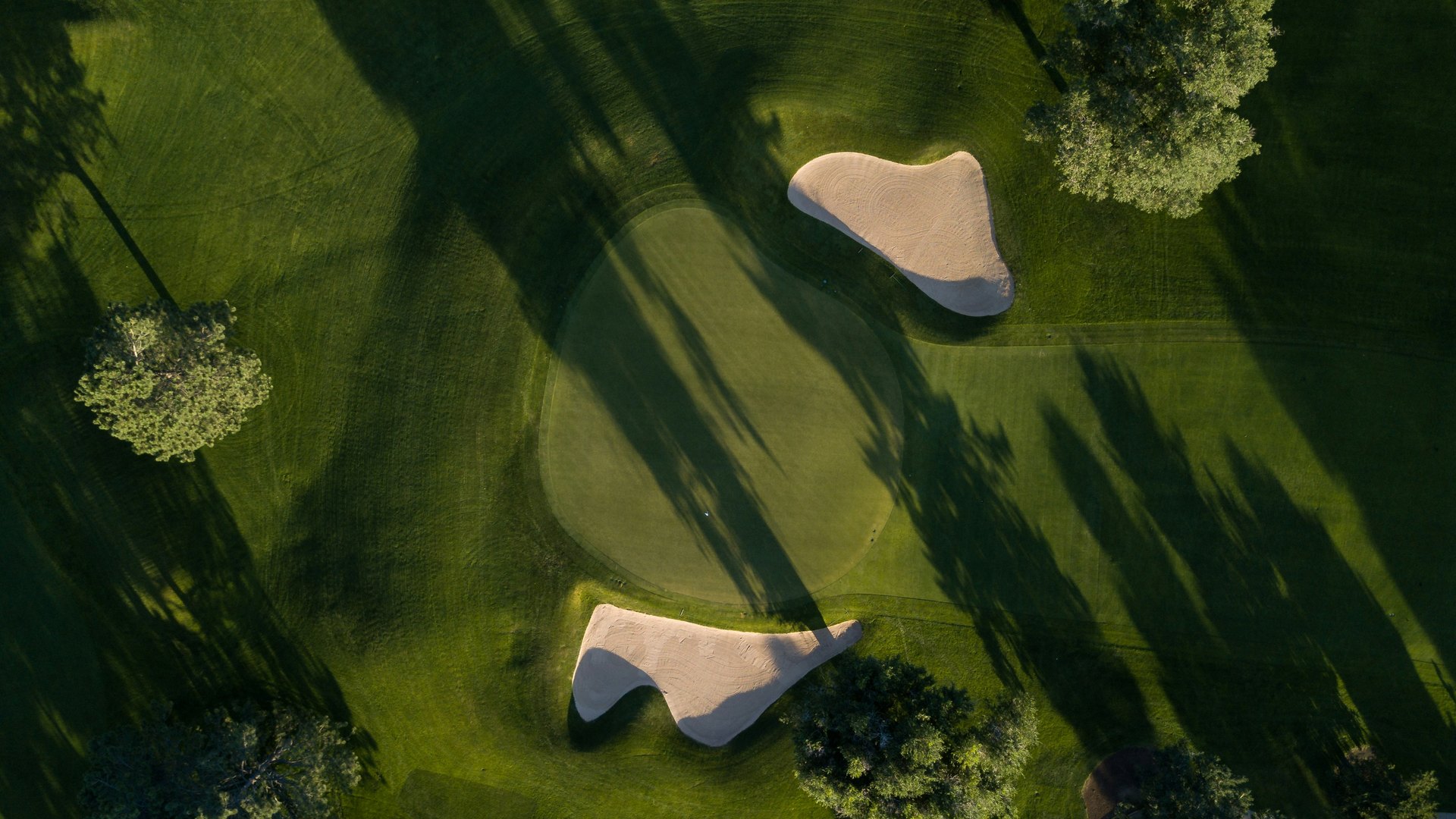 Aerial view of a manicured golf course at golden hour